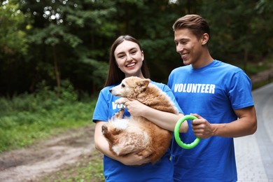 Photo of Happy volunteers with cute stray dog outdoors