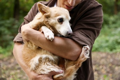 Photo of Man holding his cute dog outdoors, closeup
