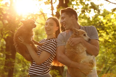 Photo of Happy couple holding their cute dogs outdoors
