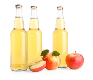 Photo of Delicious cider in glass bottles and apples isolated on white