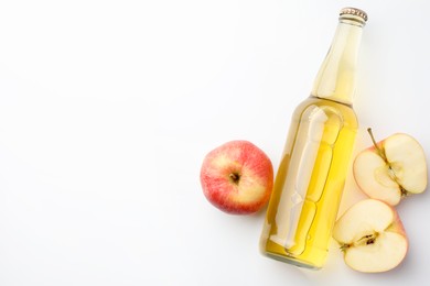 Photo of Delicious cider in glass bottle and apples on white background, flat lay. Space for text