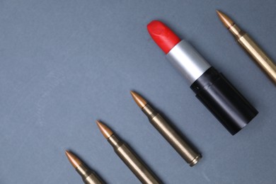 Photo of Red lipstick among bullets on grey background, flat lay. Space for text