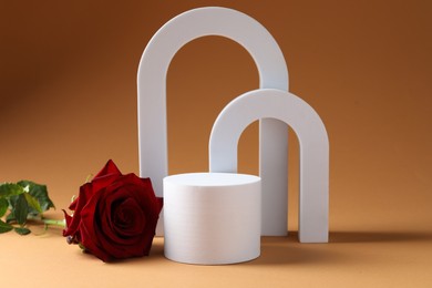 Photo of Promotion. White figures, podium and rose flower on brown background