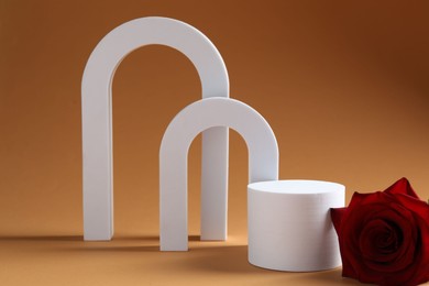 Photo of Promotion. White figures, podium and rose flower on brown background