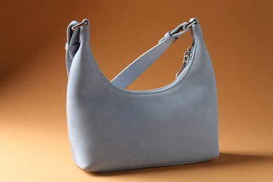 Photo of Promotion. Stylish light gray bag on brown background
