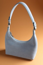 Photo of Promotion. Stylish light gray bag on brown background