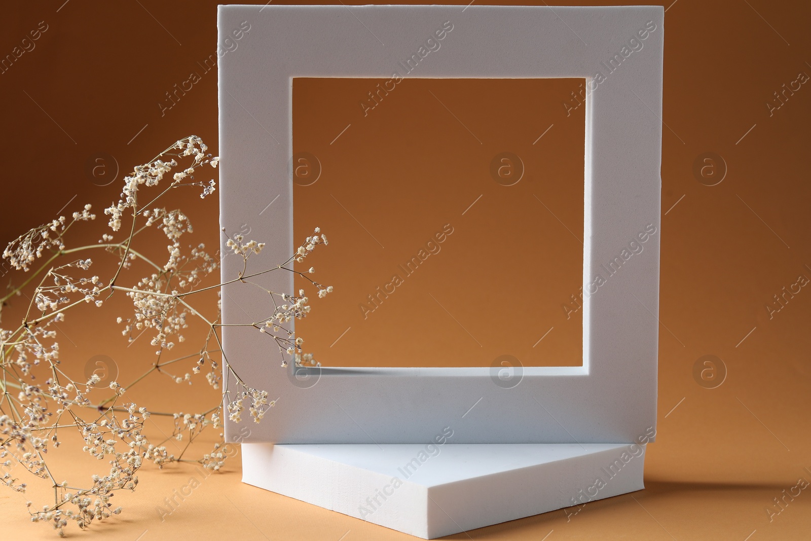 Photo of Promotion. White figure and gypsophila flowers on brown background