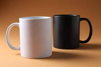 Photo of Promotion. White and black mugs on brown background
