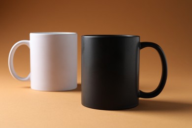 Photo of Promotion. White and black mugs on brown background