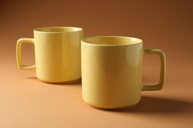 Photo of Promotion. Two yellow mugs on brown background