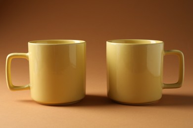 Photo of Promotion. Two yellow mugs on brown background