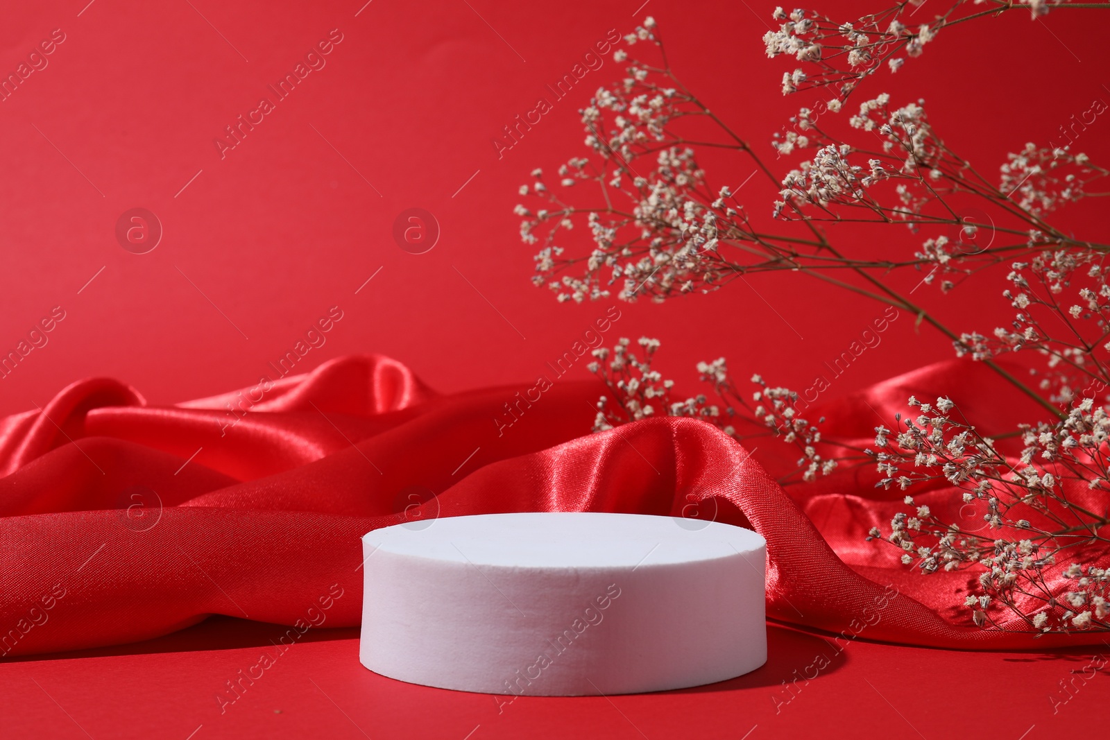 Photo of Promotion. Podium for product presentation, fabric and gypsophila flowers on red background