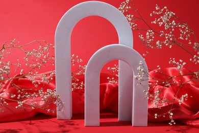 Photo of Promotion. White figures, fabric and gypsophila flowers on red background