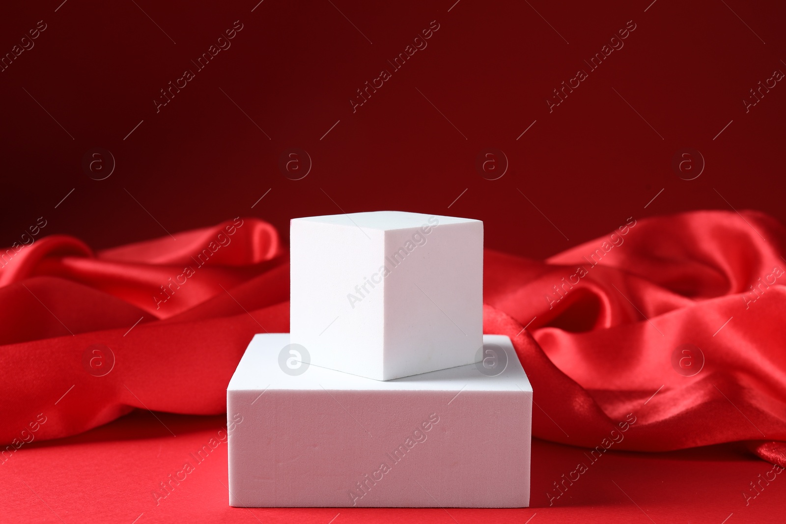 Photo of Promotion. Podiums for product presentation and fabric on red background