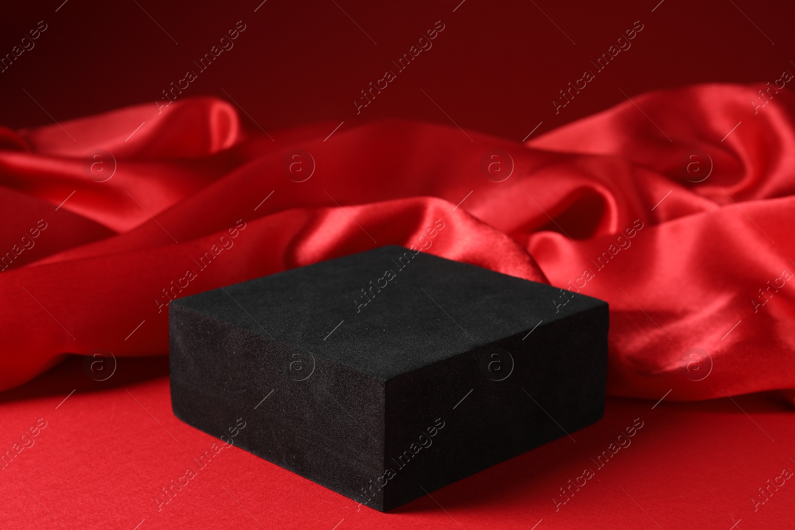 Photo of Promotion. Podium for product presentation and fabric on red background