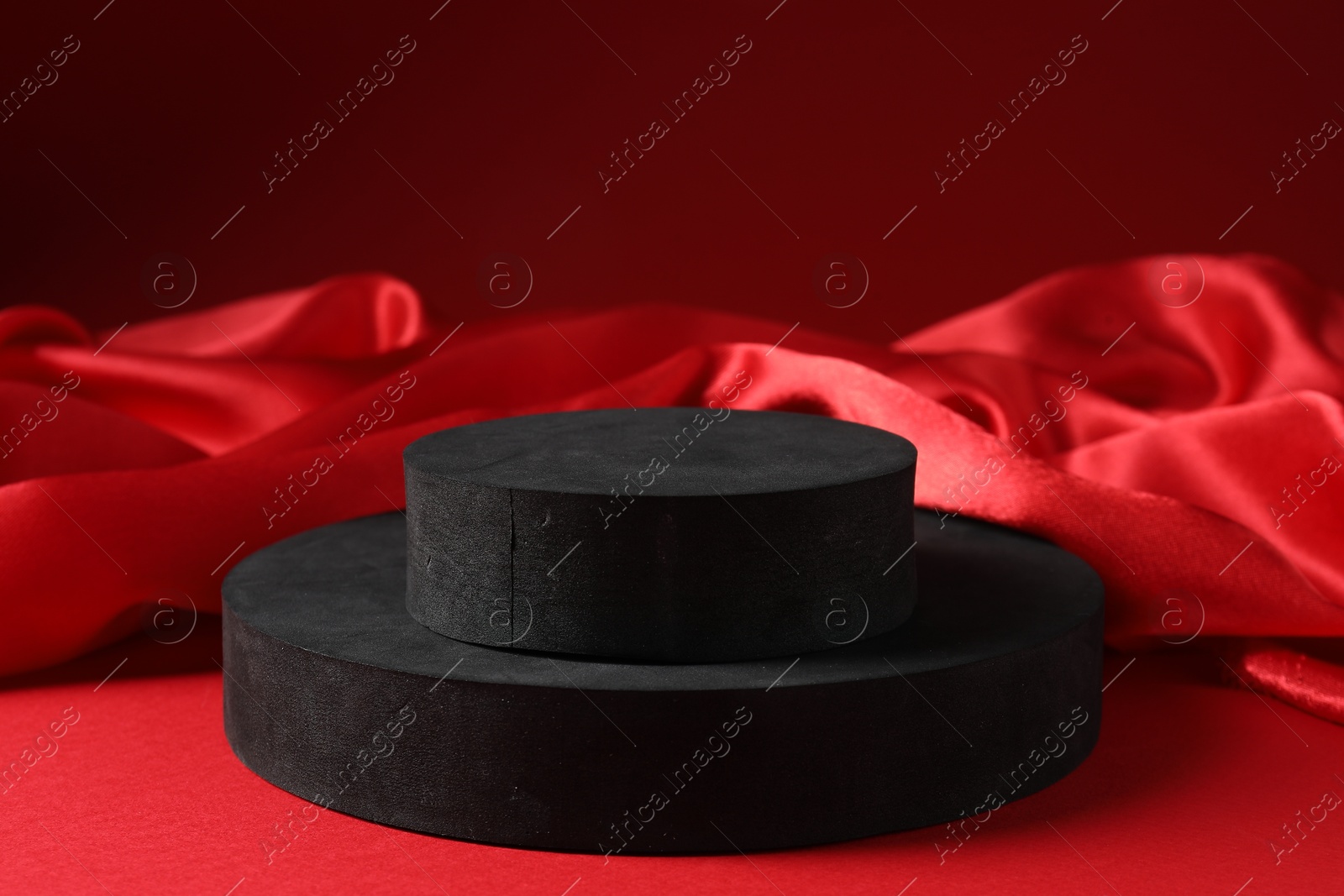 Photo of Promotion. Podiums for product presentation and fabric on red background