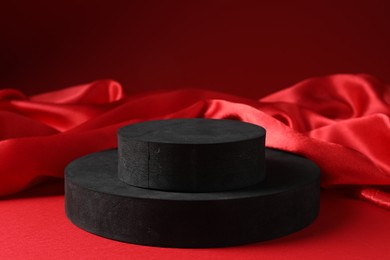 Photo of Promotion. Podiums for product presentation and fabric on red background