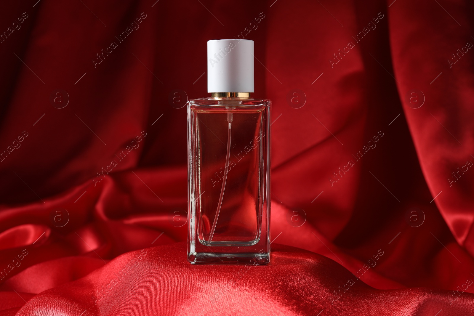 Promotion. One perfume bottle on red fabric Photo of Promotion. One perfume bottle on red fabric