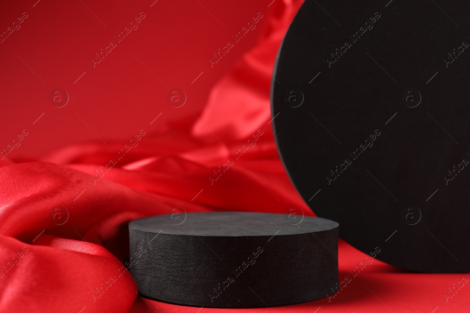 Photo of Promotion. Black figures and fabric on red background