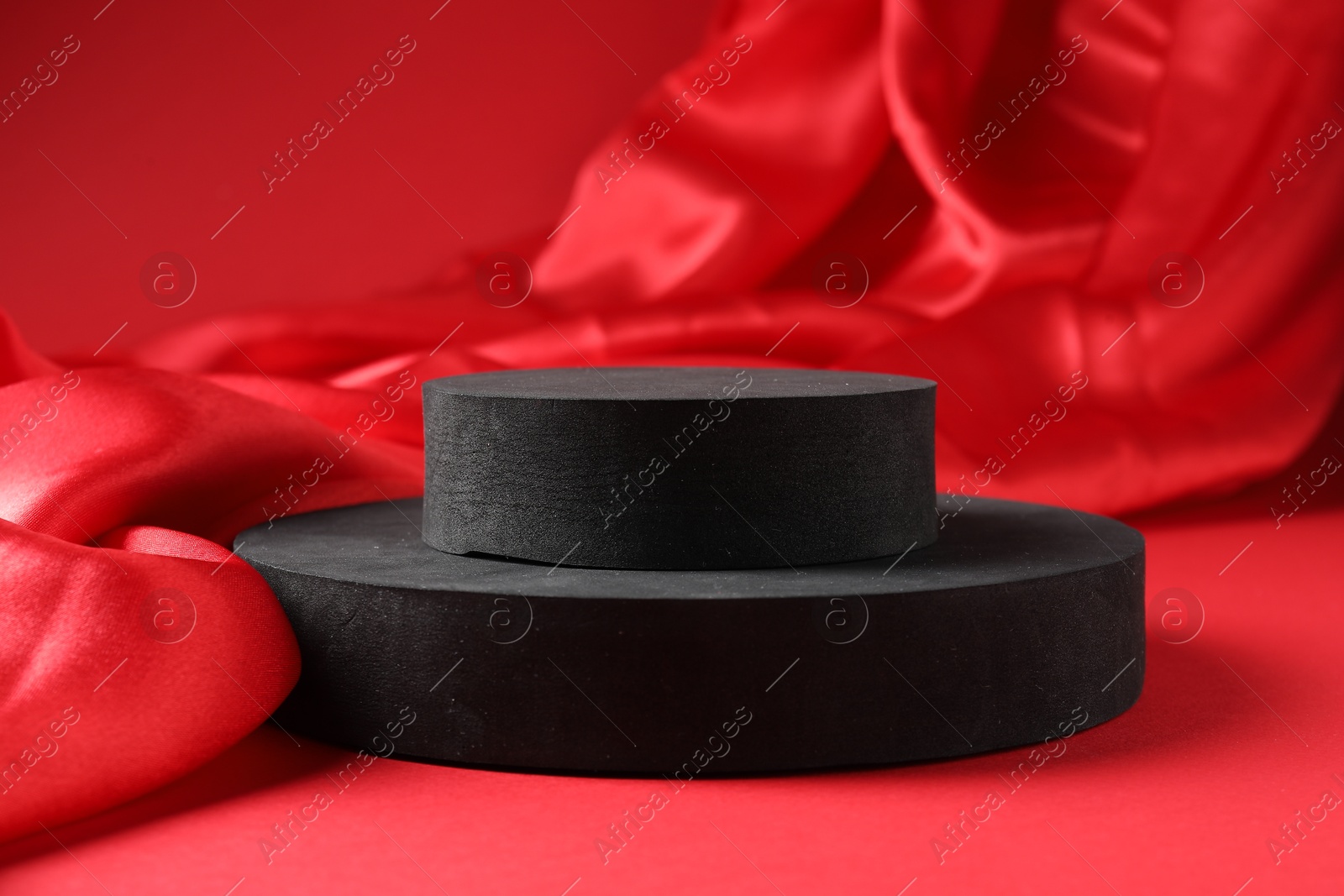 Photo of Promotion. Podiums for product presentation and fabric on red background