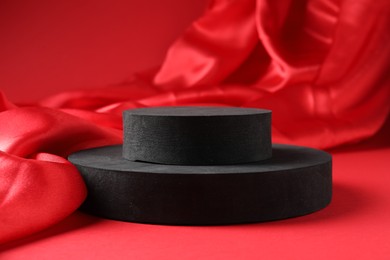 Photo of Promotion. Podiums for product presentation and fabric on red background