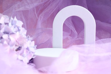 Photo of Promotion. White figures and hydrangea flowers on violet fabric