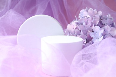 Photo of Promotion. White figures and hydrangea flowers on violet fabric