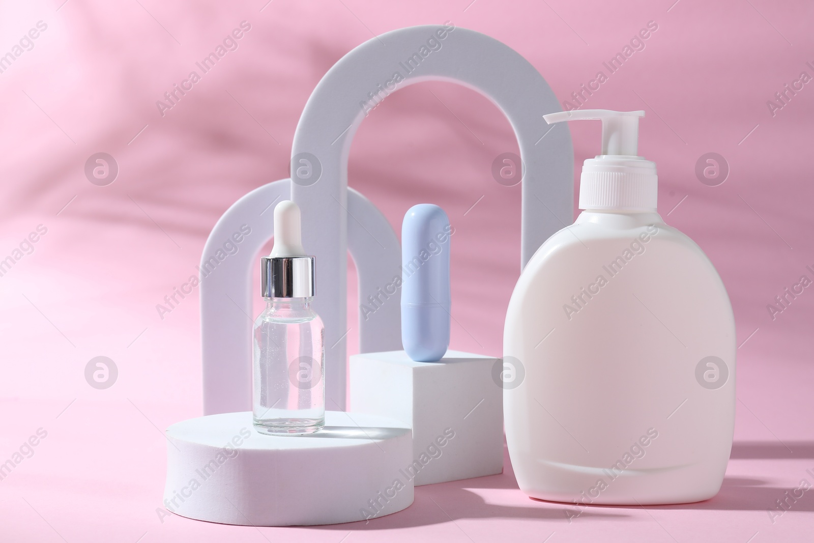 Photo of Promotion. Cosmetic products and podiums on pink background