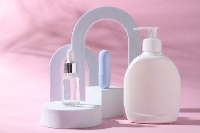 Photo of Promotion. Cosmetic products and podiums on pink background