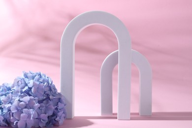 Photo of Promotion. White figures for product presentation and hydrangea flowers on pink background