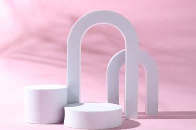 Photo of Promotion. Different podiums for product presentation on pink background