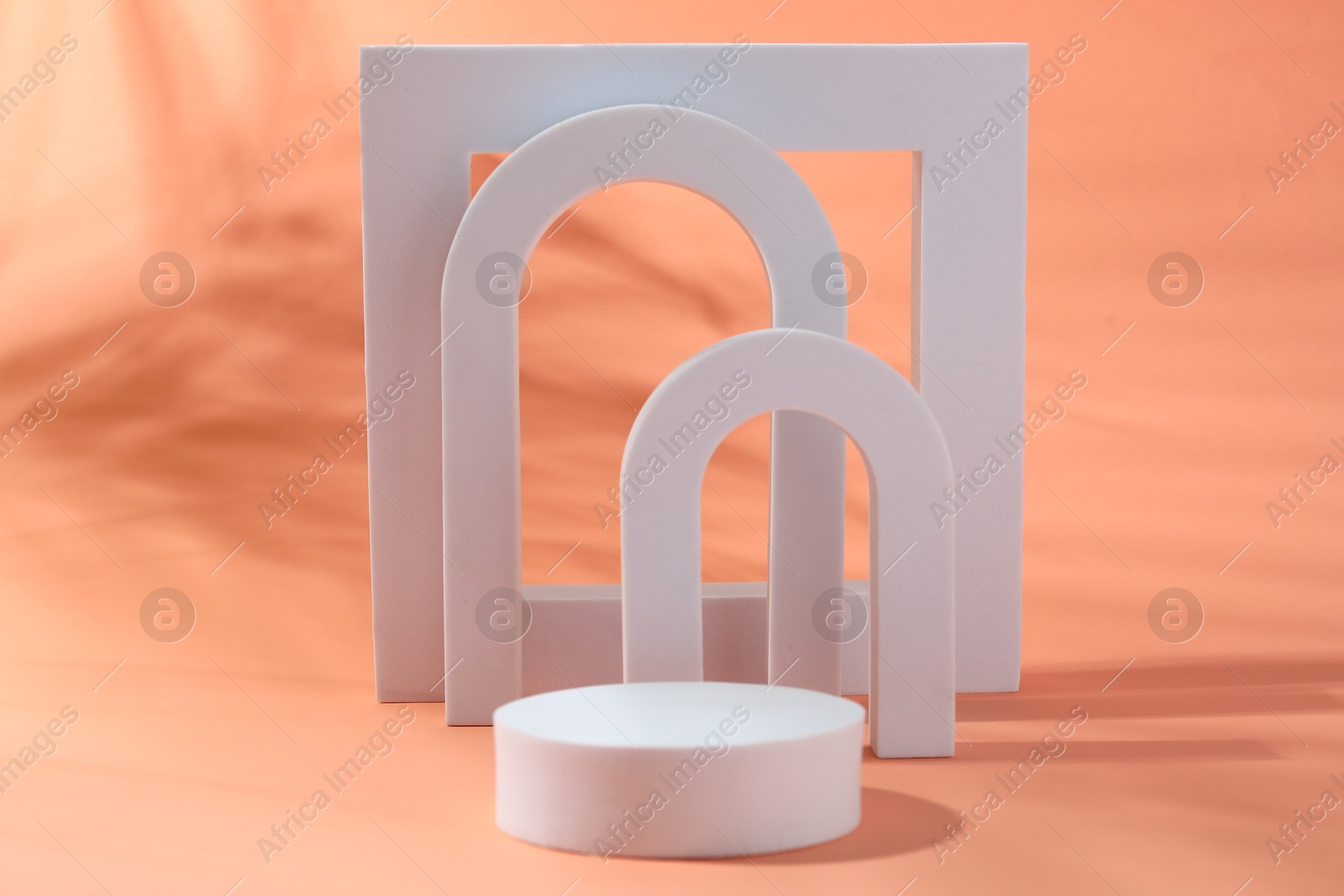 Photo of Promotion. Different white figures for product presentation on coral background