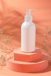 Photo of Promotion. Bottle of cosmetic product, podiums and gypsophila flowers on color background