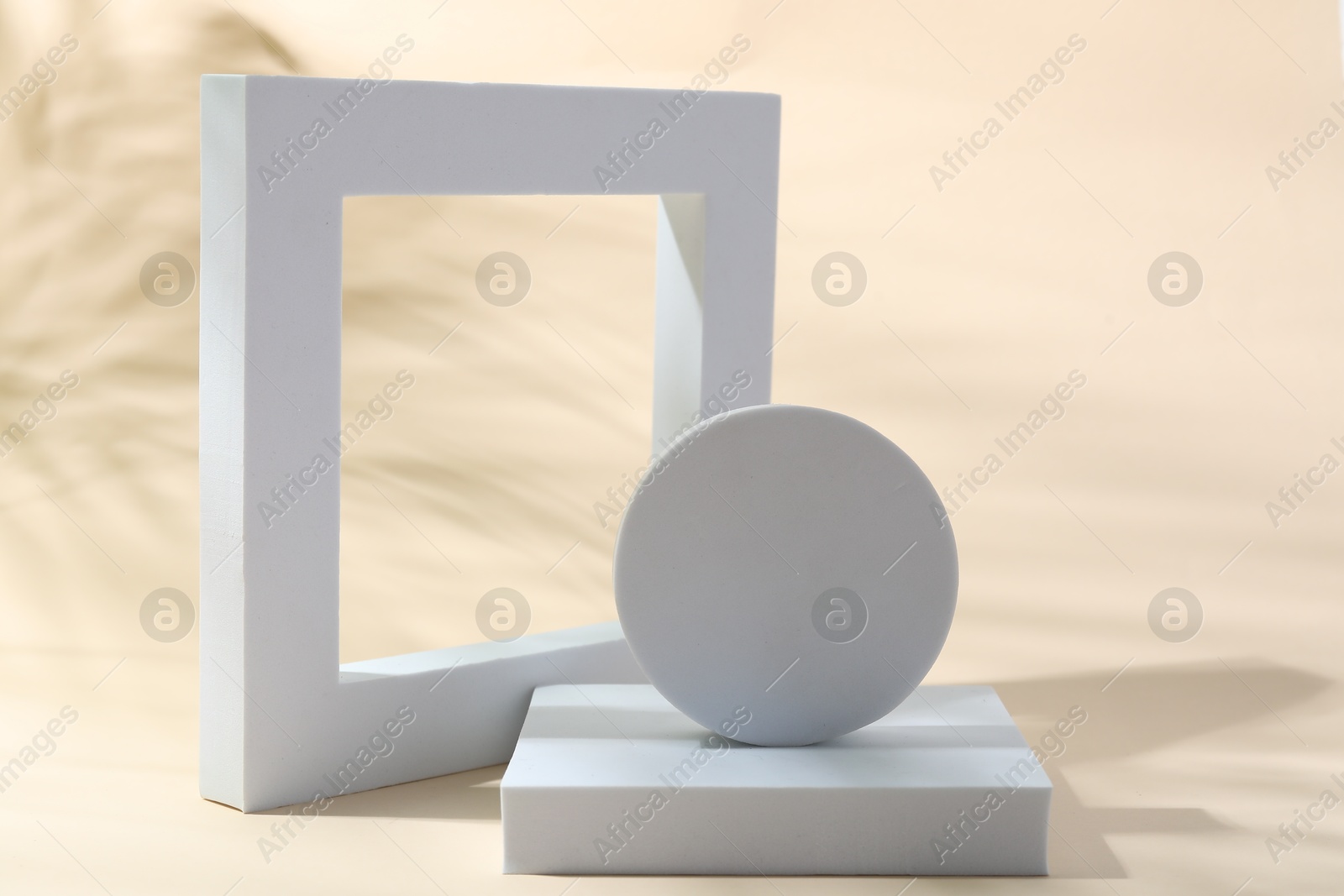 Photo of Promotion. Different white figures for product presentation on beige background