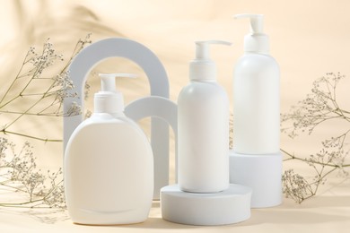 Photo of Promotion. Cosmetic products, podiums and gypsophila flowers on beige background