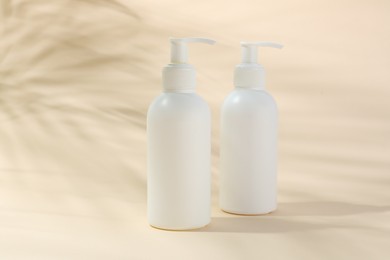 Photo of Promotion. Bottles of cosmetic products on beige background