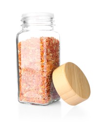 Photo of Dried carrots in glass jar isolated on white. Aromatic spice