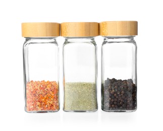 Photo of Aromatic spices in glass jars isolated on white