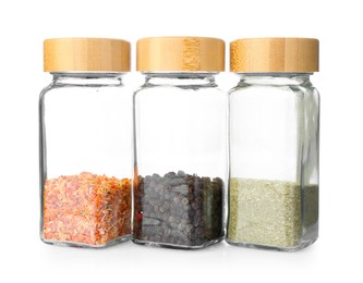 Photo of Aromatic spices in glass jars isolated on white