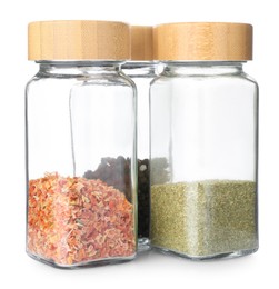 Photo of Aromatic spices in glass jars isolated on white