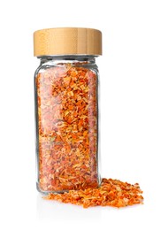 Photo of Dried carrots in glass jar isolated on white. Aromatic spice