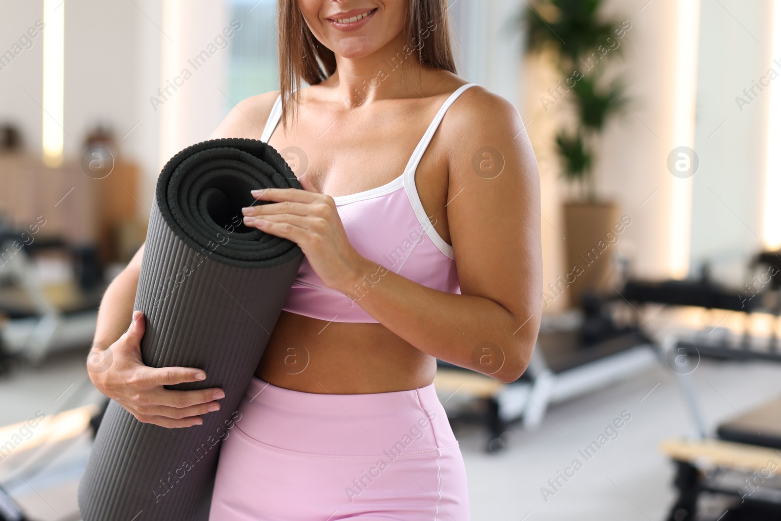 Woman with fitness mat in pilates studio, closeup Photo of Woman with fitness mat in pilates studio, closeup