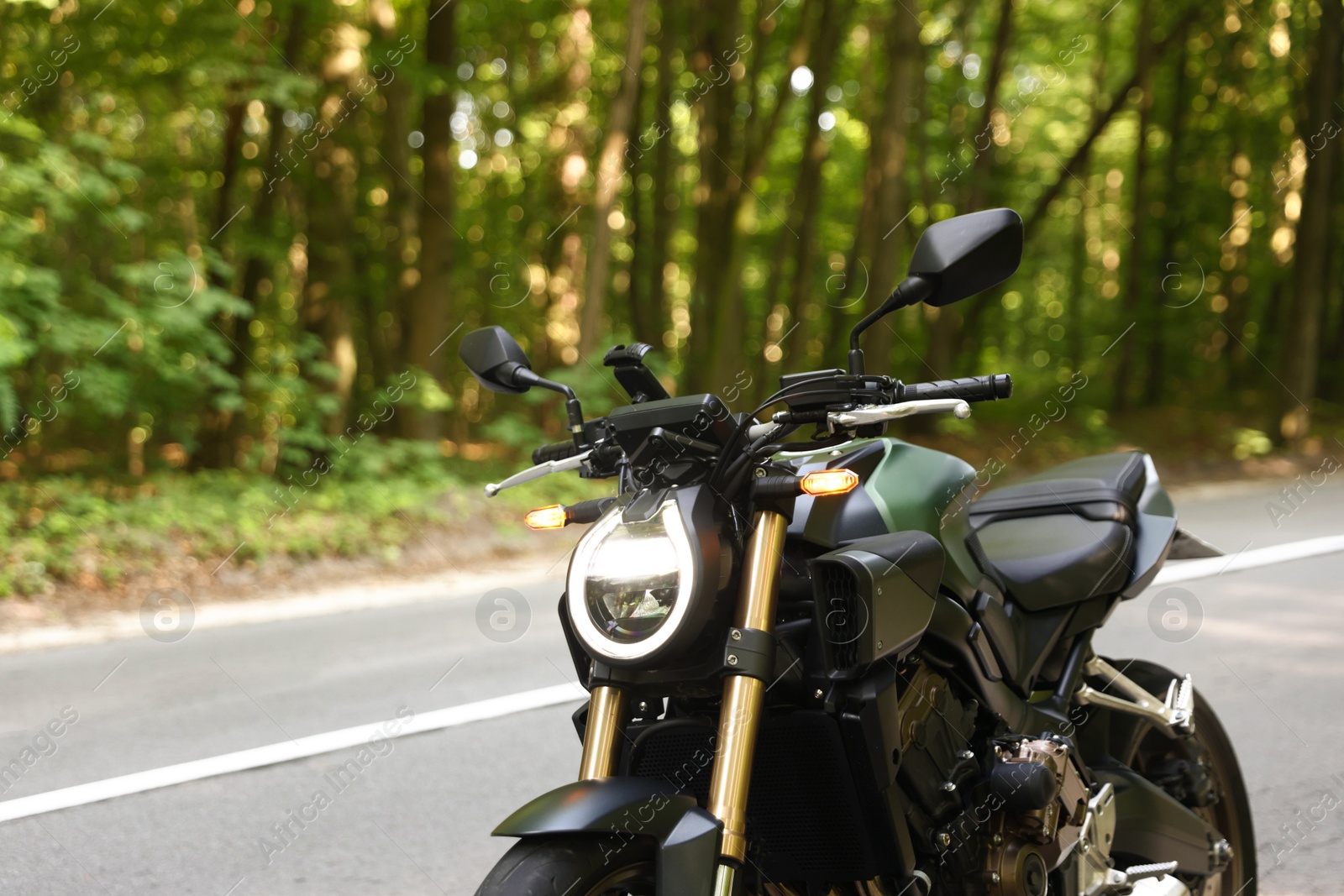 Modern black motorcycle parked on road outdoors. Space for text Photo of Modern black motorcycle parked on road outdoors. Space for text