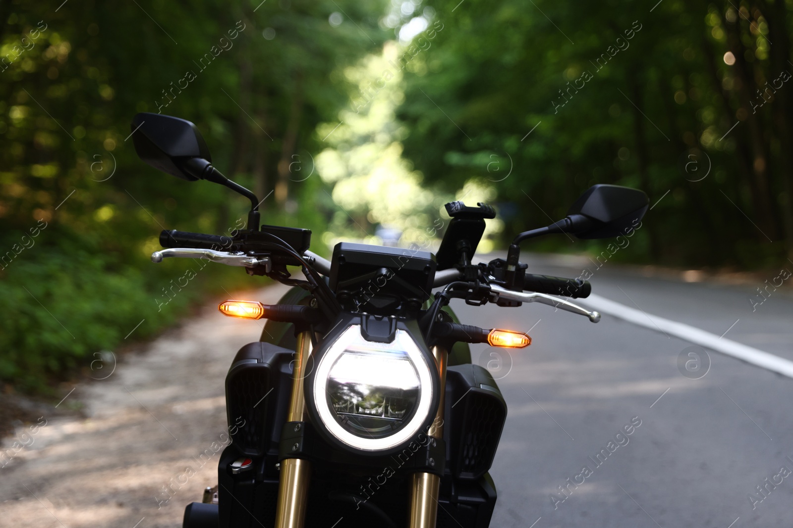 Modern black motorcycle parked on road outdoors Photo of Modern black motorcycle parked on road outdoors