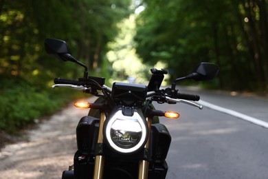 Photo of Modern black motorcycle parked on road outdoors