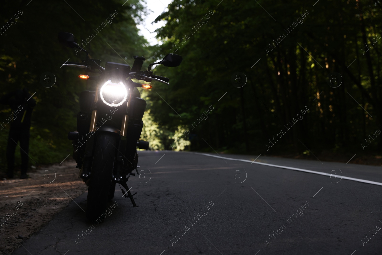 Modern black motorcycle parked on road outdoors. Space for text Photo of Modern black motorcycle parked on road outdoors. Space for text