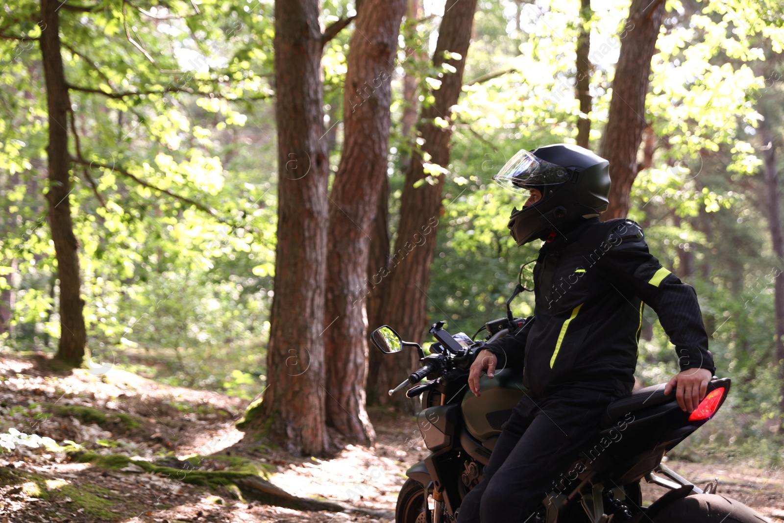 Photo of Young man in helmet with modern motorcycle outdoors. Space for text