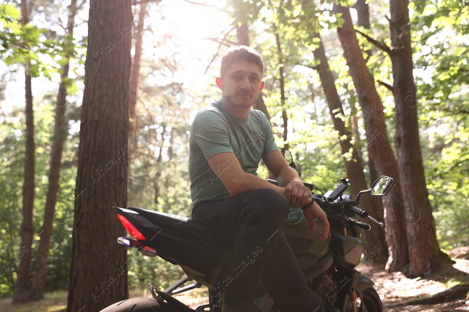 Handsome young man with modern motorcycle outdoors Photo of Handsome young man with modern motorcycle outdoors