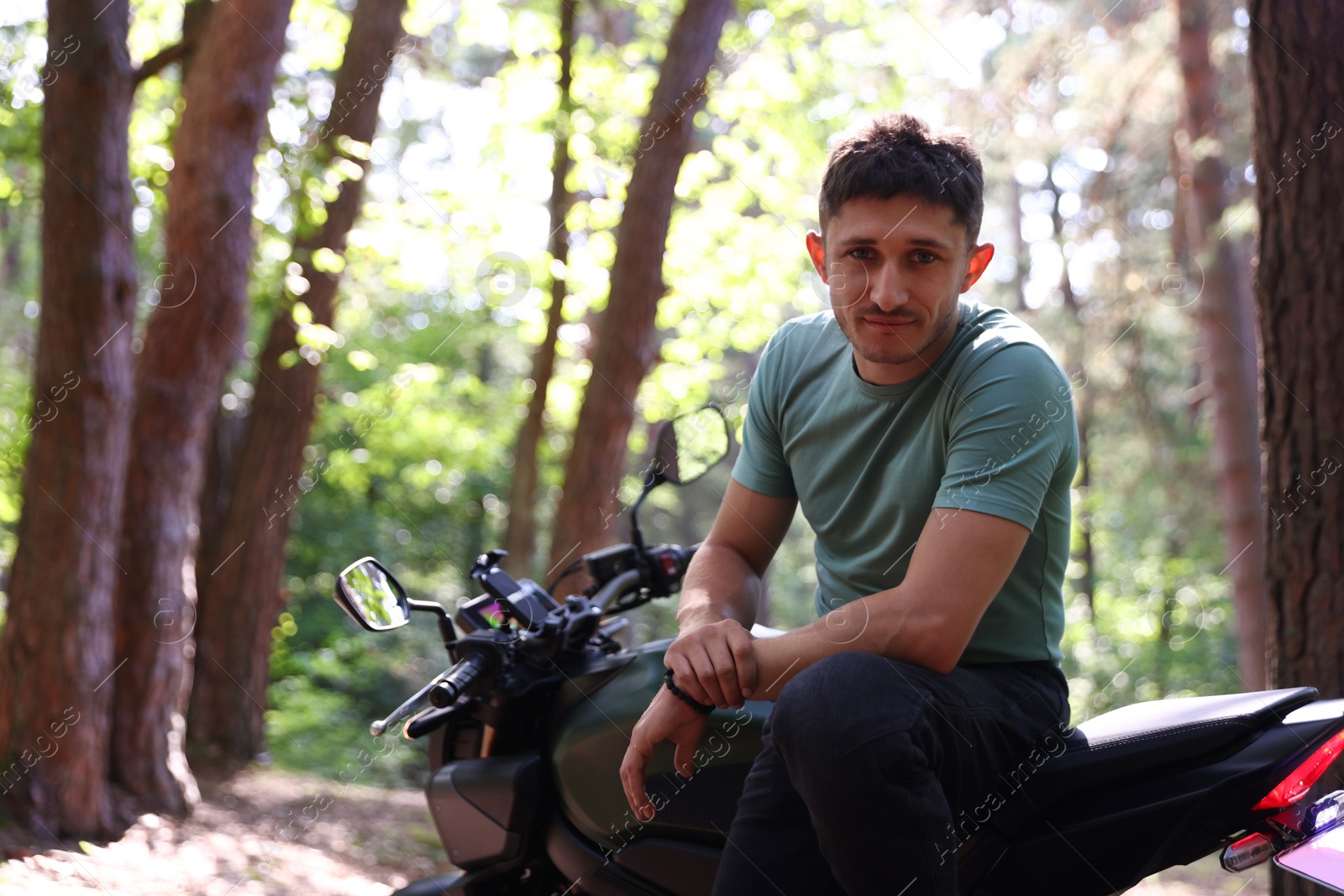 Handsome young man with modern motorcycle outdoors. Space for text Photo of Handsome young man with modern motorcycle outdoors. Space for text