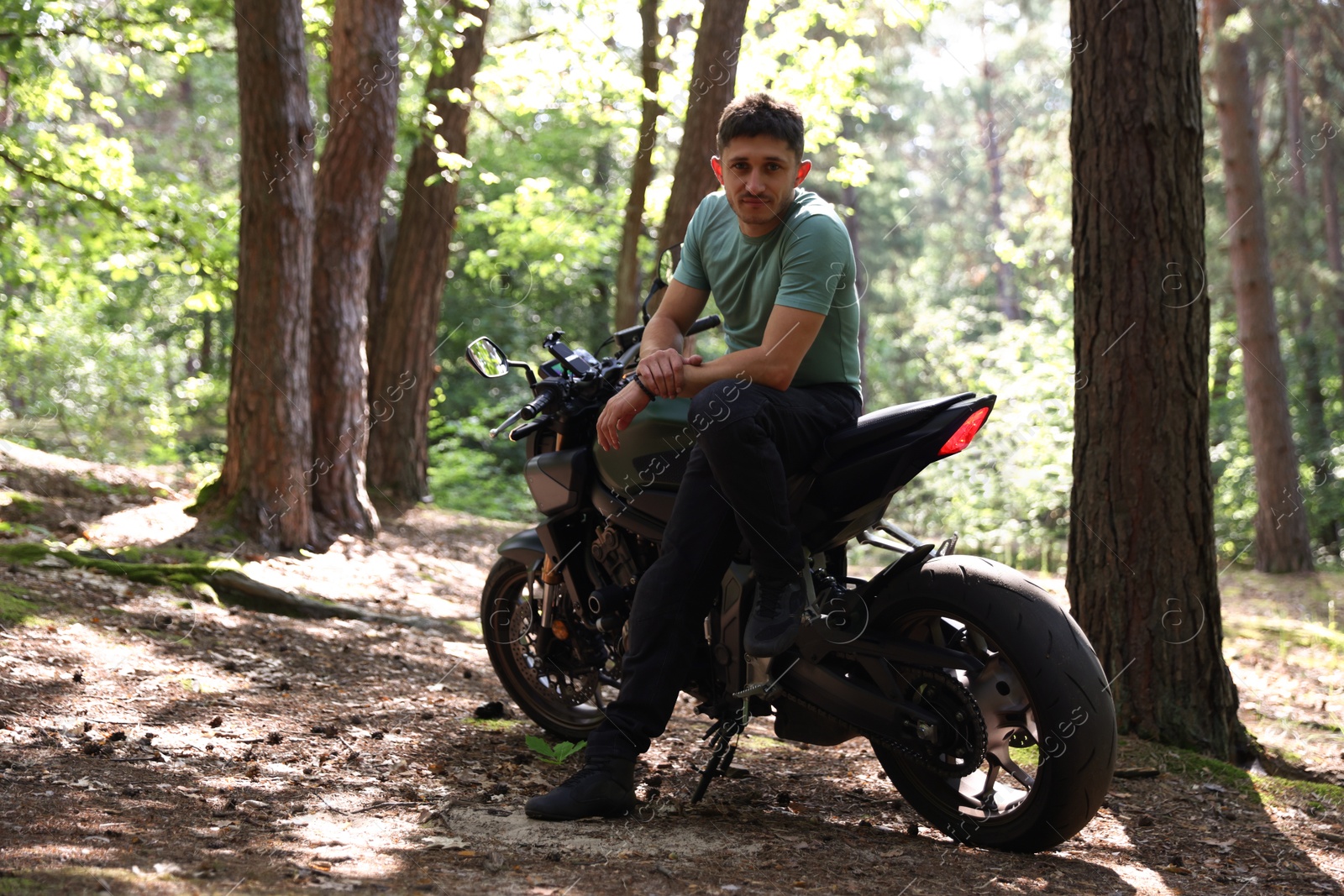 Handsome young man with modern motorcycle outdoors. Space for text Photo of Handsome young man with modern motorcycle outdoors. Space for text